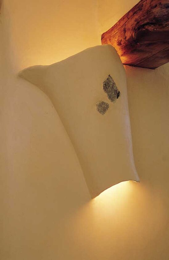 Not ones to settle for off-the-shelf fixtures, Tom and Flame formed wall sconces with chicken wire, then extended the wall plaster (Structo-Lite) around the wire for a seamless look. They “dressed up” the sconces by embedding bits of turquoise in the wet plaster.